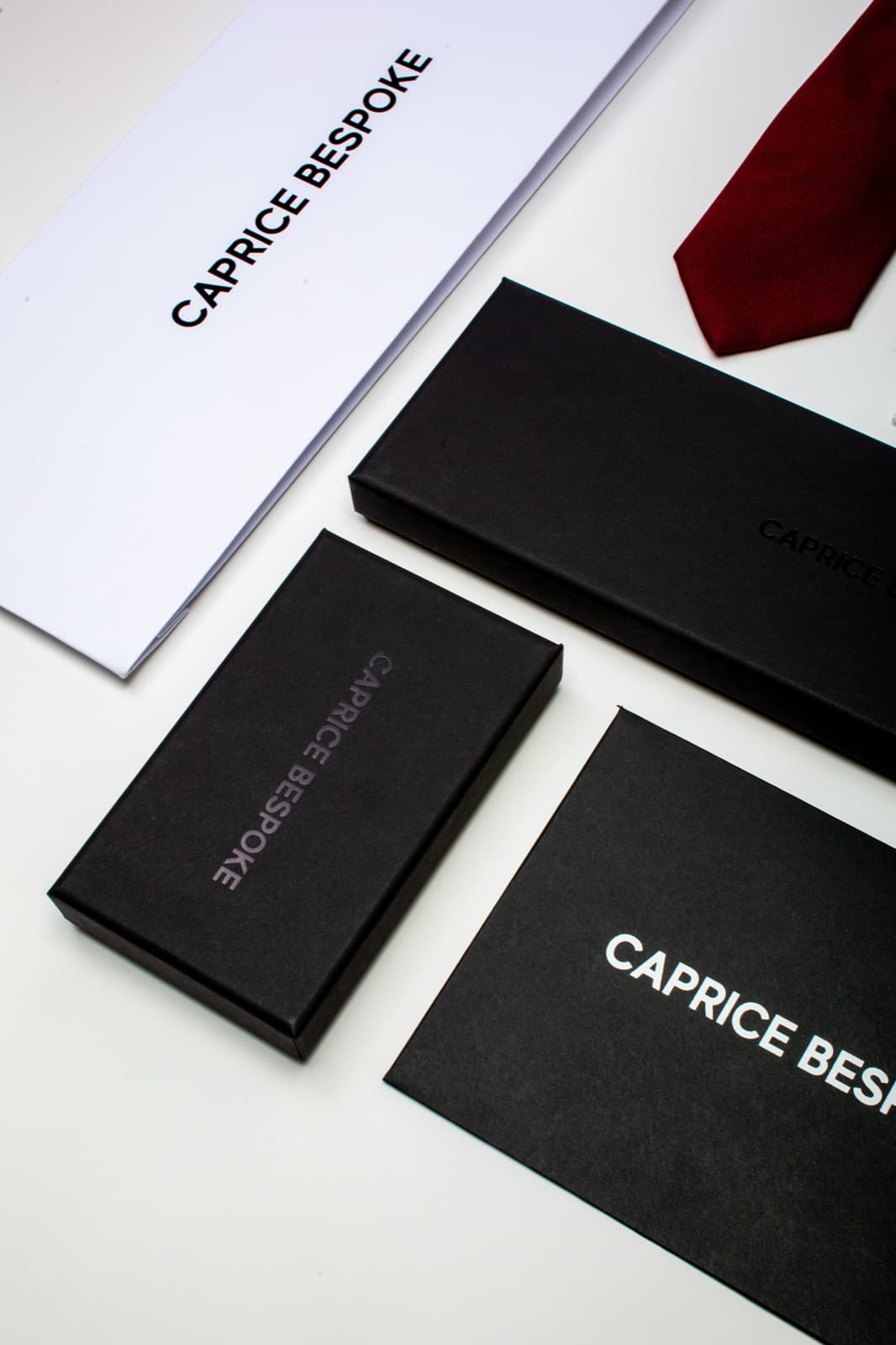Caprice Bespoke made-to-measure packaging and a silk tie — luxury menswear delivered