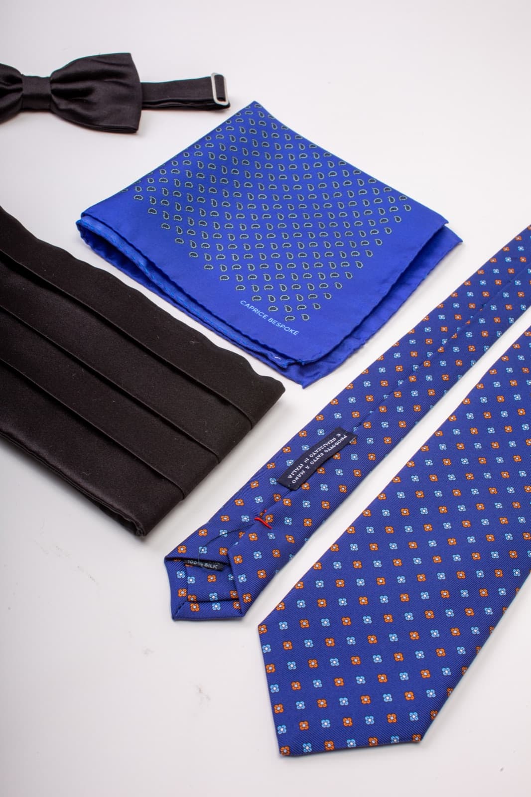 A collection of Caprice Bespoke silk accessories — bow tie, pocket square and ties