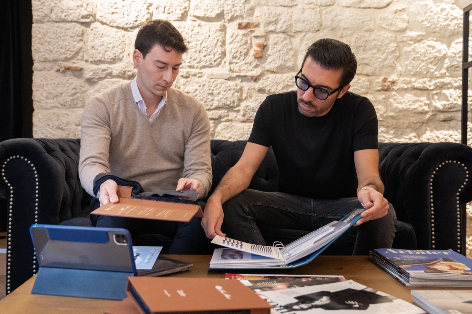 A Caprice style advisor reviewing fabric books and a tablet with a client