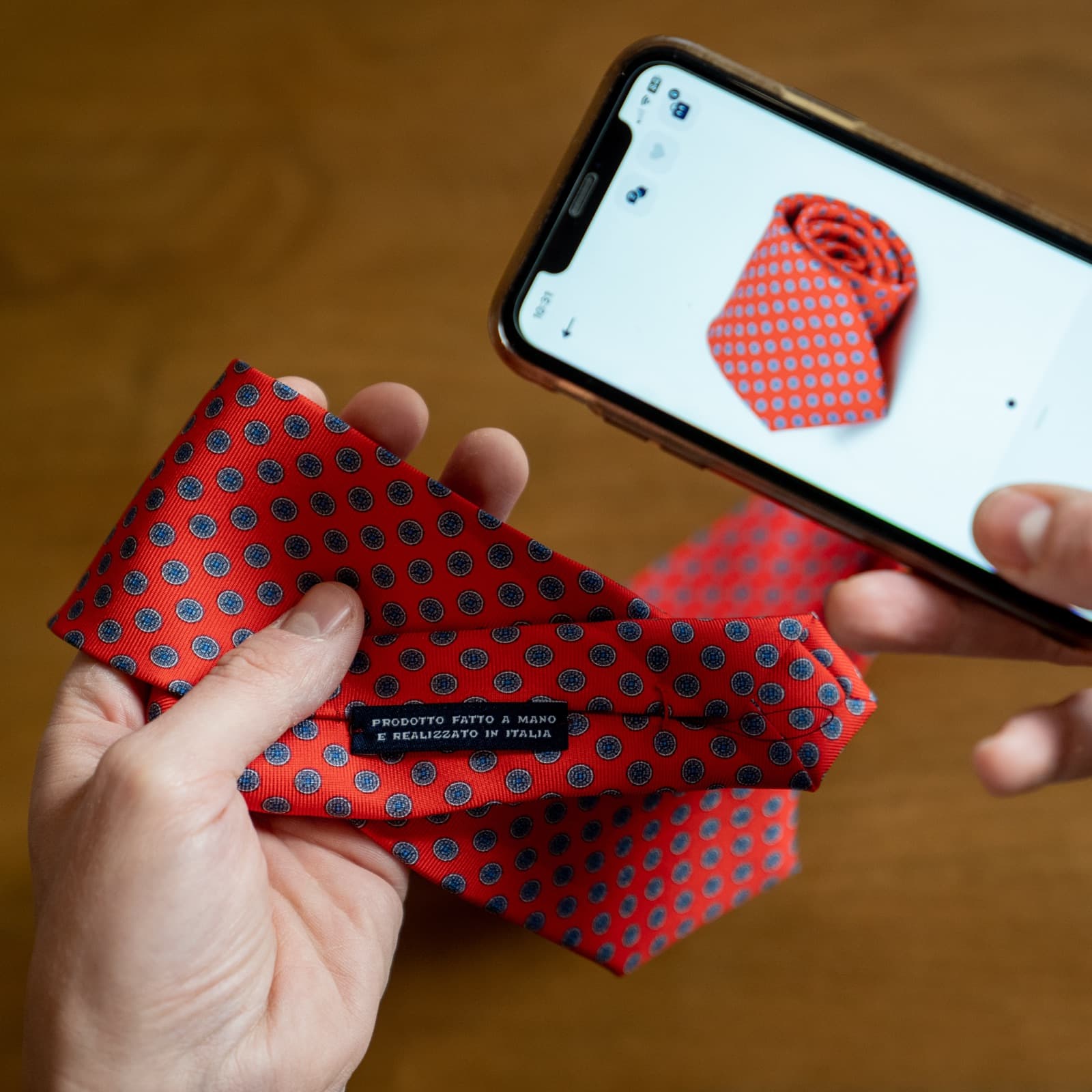 A hand holding a Caprice Bespoke silk tie beside a phone showing the same tie in the app